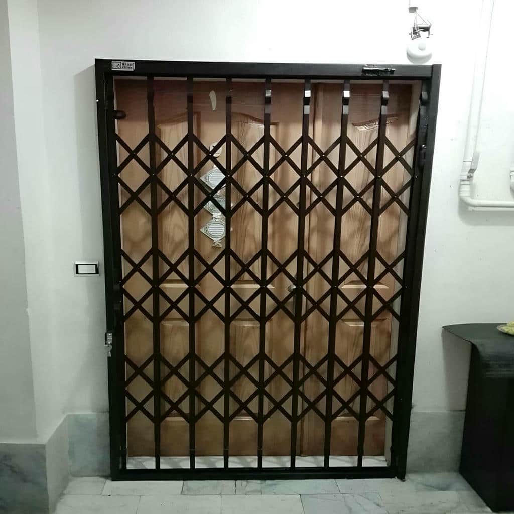 حفاظ ضربدری آکاردئونی در حالت جمع شده کنار چهارچوب